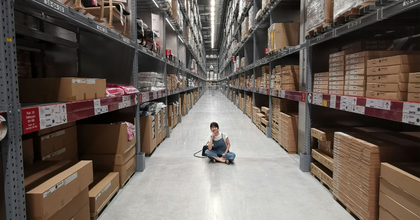 Woman sitting in stock warehouse